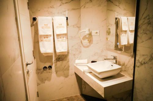 a bathroom with a sink and a shower with towels at MY HOTEL in Prizren