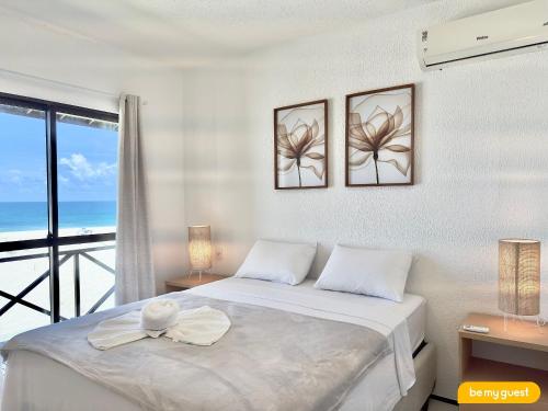 a bedroom with a bed with a view of the ocean at Beachfront Duplex B por Be My Guest in Aquiraz