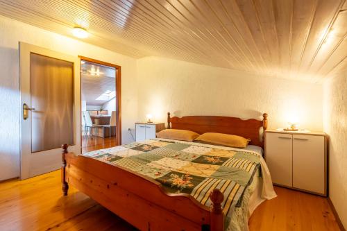a bedroom with a wooden bed with a wooden ceiling at Apartmaji Loretica in Most na Soči