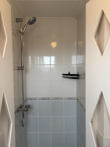 a bathroom with a shower with a glass shower door at 't Lytse Knipke in Lemmer