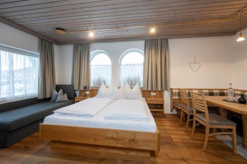 a bedroom with a large bed and a table at Obersulzberggut in Radstadt