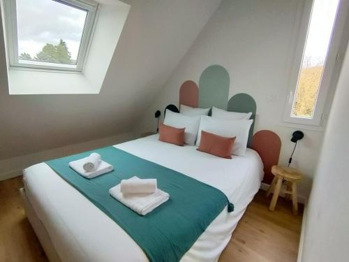 a bedroom with a large bed with towels on it at Le perchoir de Pibri - Les apparts de Maddy in Meyssac
