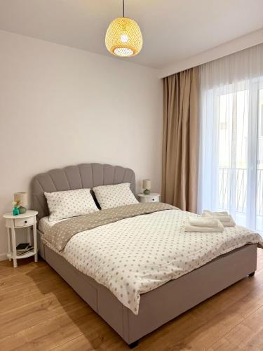 a white bedroom with a large bed and a window at Forestis Thermalis in Baile Felix