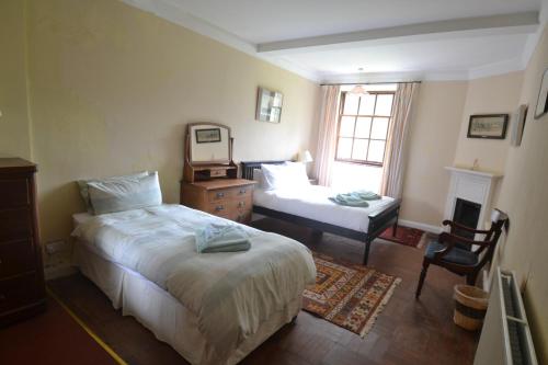 a bedroom with a bed and a desk with a mirror at Butlers Quarters Apartment in Cairndow