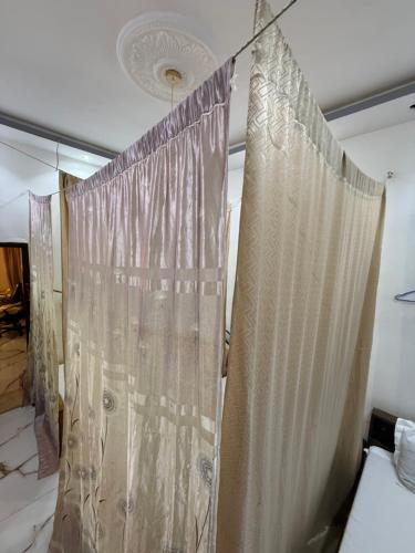 a curtain hanging in a room with a bed at Résidence Khadija, Aéroport 15mn AIBD, CICAD hôtel in Rufisque