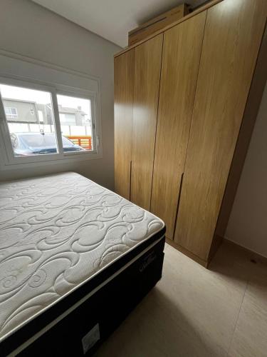 a bedroom with a bed and a wooden cabinet at Refúgio Rossa in Xangri-lá
