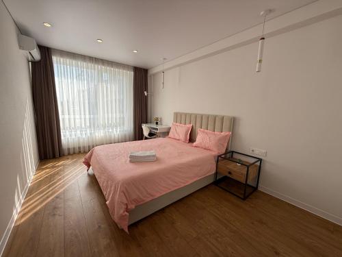 a bedroom with a large bed with pink pillows at Cruds Arena Chisinau in Chişinău