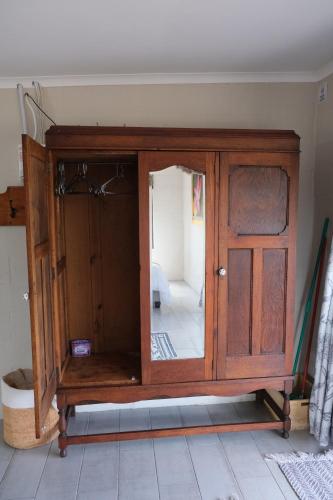 a wooden cabinet with a mirror in a room at Blue Sky Retreat in Vredenburg