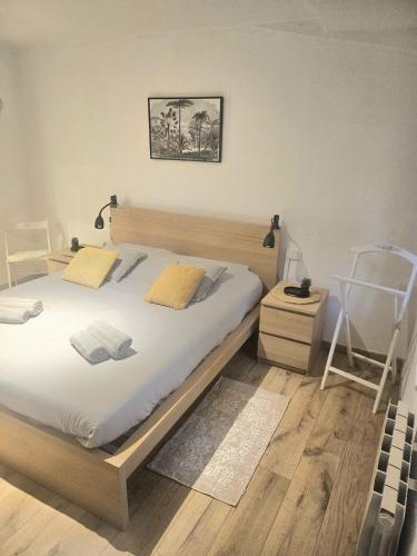 a bedroom with a large bed and a chair at La petite maison dans la bastide in Carcassonne
