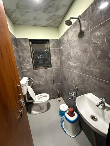 a bathroom with a toilet and a sink at Hotel Sumeet Palace in Shirdi