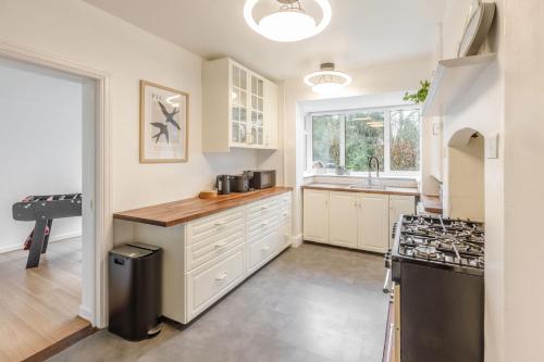 a kitchen with white cabinets and a sink at Host & Stay - Combpyne in Compton