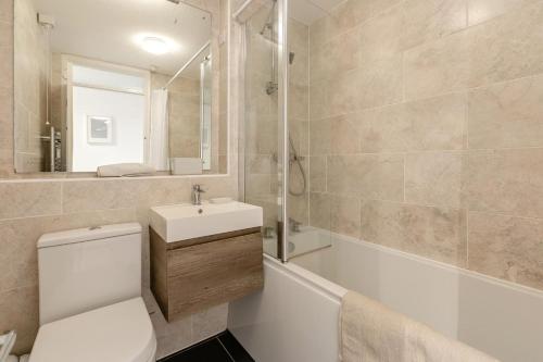 a bathroom with a toilet and a sink and a tub at 2 Bed in Woolacombe oc-beache in Woolacombe