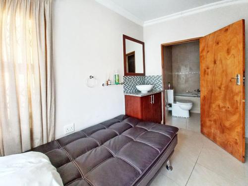 a bedroom with a bed and a bathroom with a sink at Tuscany By The Sea in Port Edward