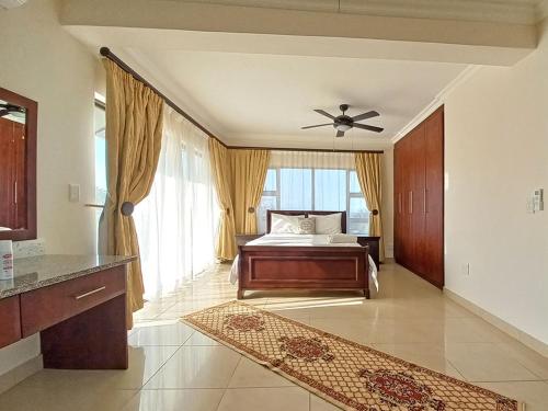 a bedroom with a bed and a ceiling fan at Tuscany By The Sea in Port Edward