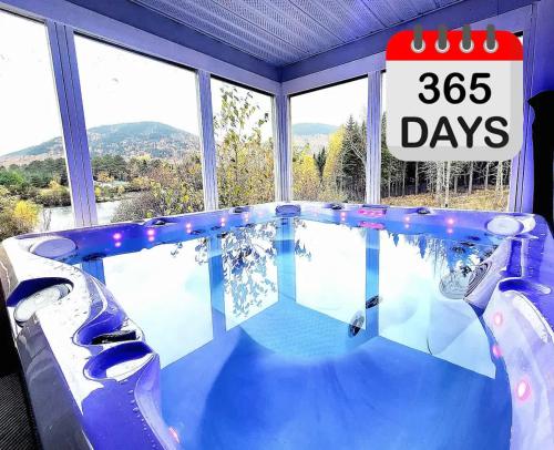 a large swimming pool with a sign that reads days at Lakeside Getaway #5 Spa Sauna Firepit in Sainte Brigitte de Laval