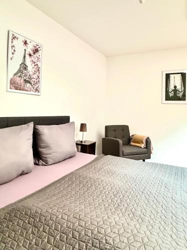 a bedroom with a large bed and a chair at Der Stader Turmblick in Stade