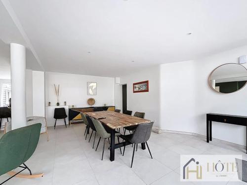 a dining room with a wooden table and chairs at L'Instant Elégant - Plage à 100m in Bray-Dunes