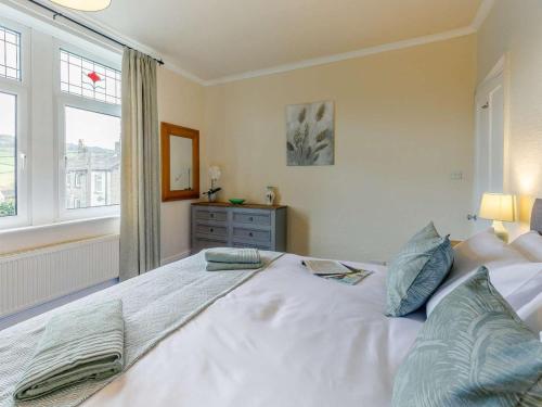a bedroom with a large white bed with blue pillows at 4 Bed in Holmfirth oc-86032 in Holmfirth