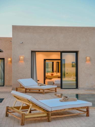 a patio with two lounge chairs and a bedroom at Palais Victoria in El Aïn