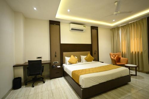 ein Hotelzimmer mit Bett, Schreibtisch und Stuhl in der Unterkunft Rohika AAU-IGH in Guwahati