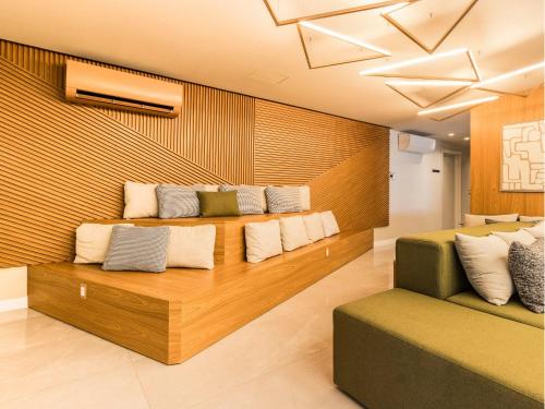 a room with a bench with pillows on it at Connect João Wallig by My Way in Porto Alegre