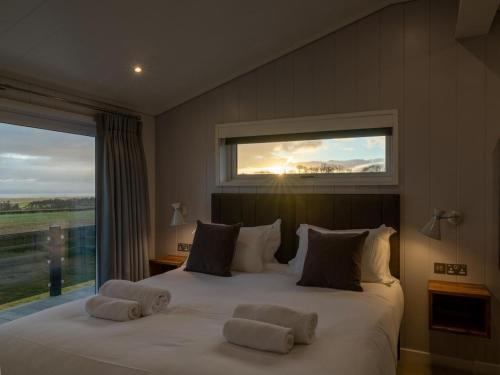 a bedroom with a large bed with towels on it at 2 Bed in Anstruther oc-72435 in Anstruther