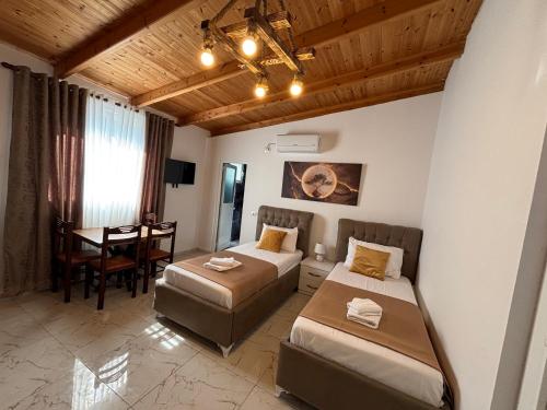 a hotel room with two beds and a table at Emiljano Seaview in Ksamil