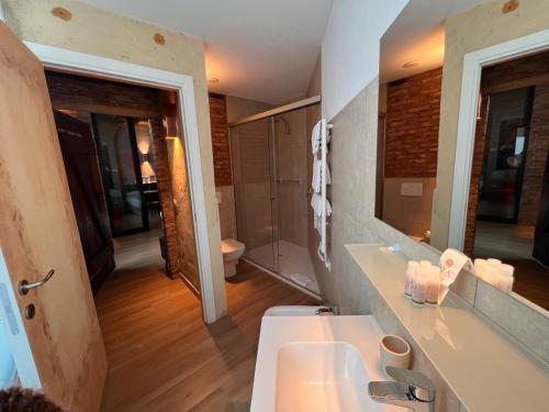 a bathroom with a sink and a toilet and a mirror at Emmeloft I Orange Moon - Vibrant Modern Luxury Loft Milan in Milan