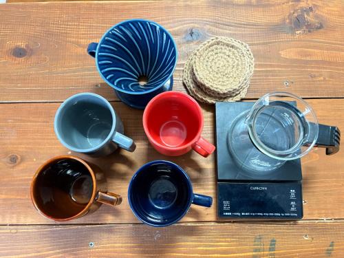 a table with cups and pots and a book on it at 島原の一棟貸し まちの宿山と朝 in Shimabara