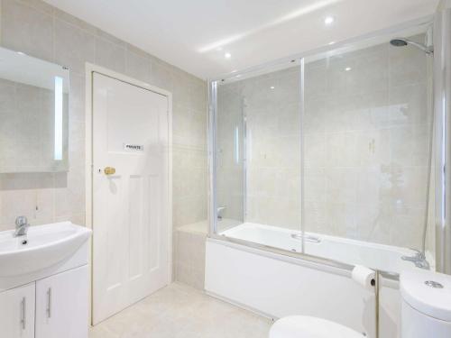 a bathroom with a shower and a tub and a sink at 5 Bed in Wareham oc-dc032 in West Lulworth