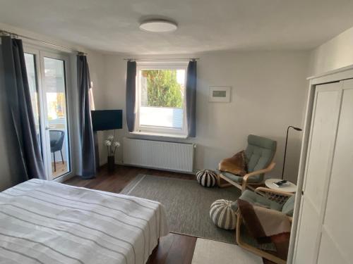 a bedroom with a bed and a chair and a window at Ferienwohnung Pauline in Plön