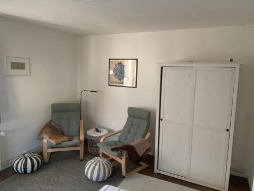 a living room with two chairs and a closet at Ferienwohnung Pauline in Plön