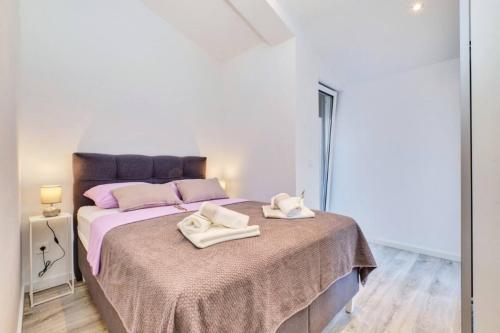 a bedroom with a bed with two white towels on it at Beautiful new apartment Blaz in Mali Lošinj