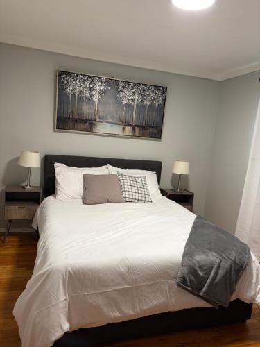 a bedroom with a large white bed with two lamps at Lonnie in Westland