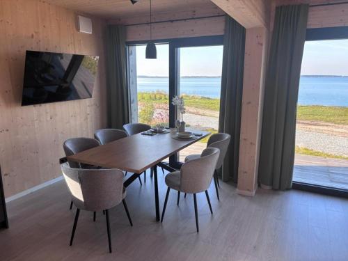 a dining room with a wooden table and chairs at Ferienhaus Sonnenwasser am Partwitzer See in Klein Partwitz