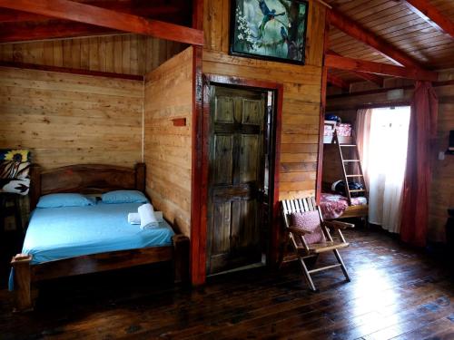 a bedroom with a bed in a wooden cabin at Las Bromelias Lodge in Paso Macho