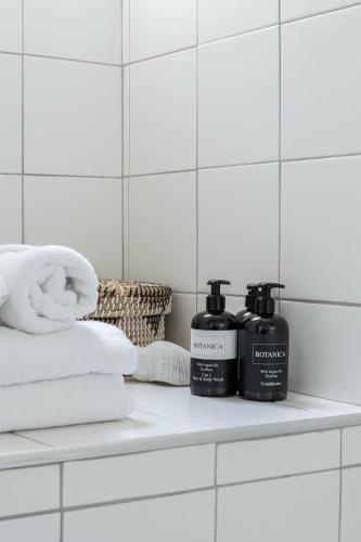 a shelf with two bottles of soap and towels at Saronida Coastal Escape 2BR Apartment in Saronida