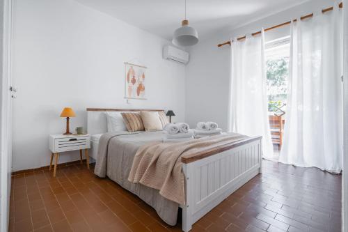 a white bedroom with a bed with towels on it at Saronida Coastal Escape 2BR Apartment in Saronida