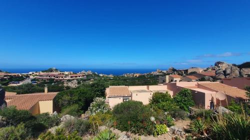 a cluster of houses on a hill with the ocean at Poolvilla Bellavista - Vista Panoramica sul Mare in Costa Paradiso