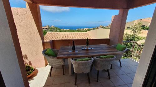 a table and chairs on a balcony with a view of the ocean at Poolvilla Bellavista - Vista Panoramica sul Mare in Costa Paradiso