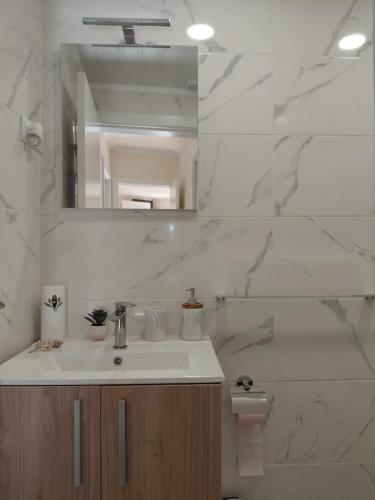 a white bathroom with a sink and a mirror at Refugio de Moncorvo in Torre de Moncorvo