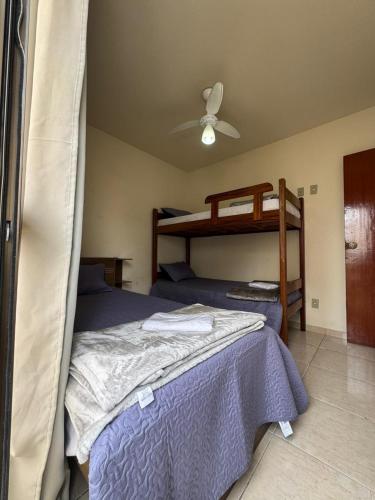 a bedroom with two beds and a ceiling fan at Praias do Sul in Cabo Frio