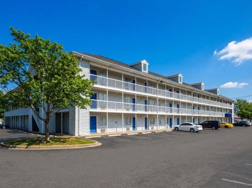 a large white building with a car parked in a parking lot at InTown Suites Extended Stay Louisville KY - Airport in Louisville