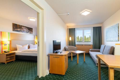 a hotel room with a bed and a couch at Hotel Am Bühl in Eibenstock