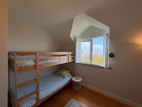 two bunk beds in a room with a window at Waterville Links in Waterville