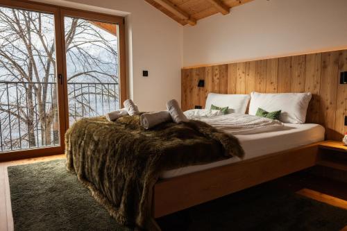 a bedroom with a large bed with a large window at Chalet Astra, Whirlpool & Sauna in San Pancrazio dʼUltimo