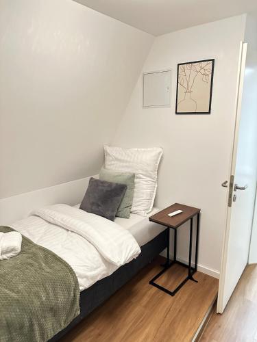 a small bedroom with a bed and a table at Altstadt Appartement in Ingolstadt