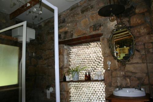 a stone bathroom with a sink and a mirror at John Jack Inn Accommodation in Chrissiesmeer