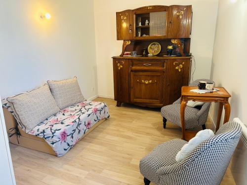 a living room with a couch and a table and chairs at Maisonnette La Chouette in Azille