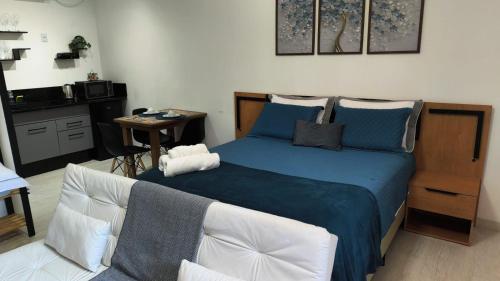 a bedroom with a blue bed and a chair at Loft Moderno Goēde in Pomerode